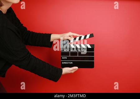 Hand-Halten-Filmklapper auf rotem Hintergrund Stockfoto