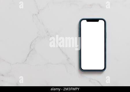 Smartphone mit leerem weißen Bildschirm im Etui auf Marmortisch, Mobiltelefon-Modell Stockfoto