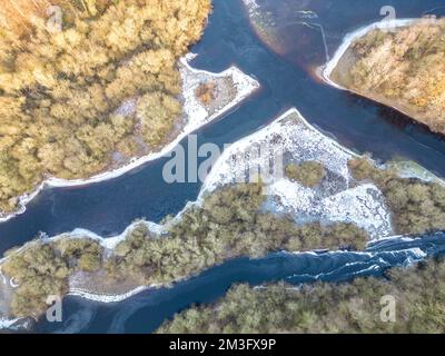 Harrogate, Großbritannien. 15.. Dezember 2022 UK Weather: Das gefrorene Swinsty Reservoir, das Teil der Yorkshire-Wasserreihe ist, die Trinkwasser liefert, wurde durch die jüngste Arktis-Explosion gefroren, beginnt jedoch zu tauen. Die Luftaufnahme des Reservoirs zeigt unterschiedliche Eisdicken über dem See, während der Feuerwehr- und Rettungsdienst von North Yorkshire Warnungen über die Gefahr von gefrorenen Teichen, Seen und Reservoirs ausgibt. Kredit: Bradley Taylor / Alamy News Stockfoto