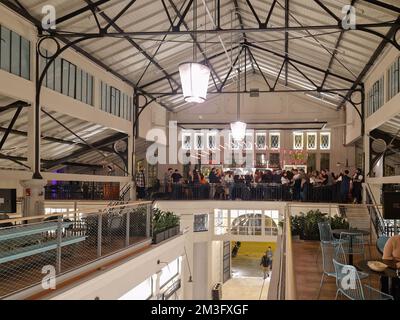 Thessaloniki, Griechenland, renovierter traditioneller Lebensmittelmarkt in Modiano. Blick von oben auf die Bar mit Menschenmassen über den Imbissständen am Abend. Stockfoto