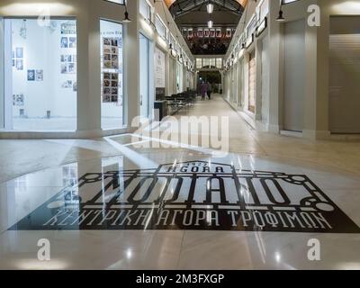 Thessaloniki, Griechenland, renovierter traditioneller Lebensmittelmarkt in Modiano. Niedriger Winkel mit Blick auf Imbissstände, mit einem neuen Schild. Stockfoto