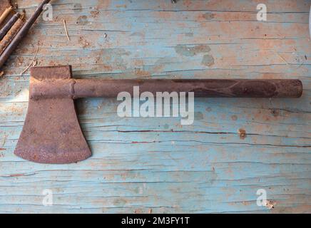 Eine alte Eisenaxt, scharfer Kopf, blauer Holzboden Stockfoto