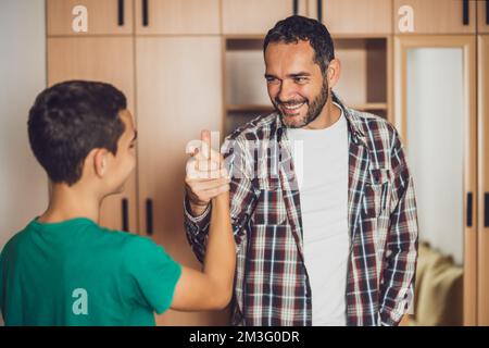 Porträt von glücklichem Vater und Sohn zu Hause. Stockfoto