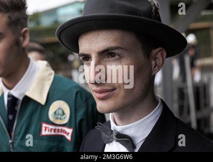 Enthusiasten ziehen sich gern in antiken Kleidern an, um die Atmosphäre des Goodwood Revival in Sussex, England, zu genießen. Stockfoto