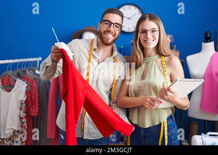 In der Bekleidungsfabrik Schneiderinnen und Schneiderinnen, die T-Shirt im Look halten Stockfoto