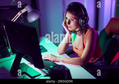Junge schöne hispanische Frau Streamer betonte mit Computer im Spielzimmer Stockfoto