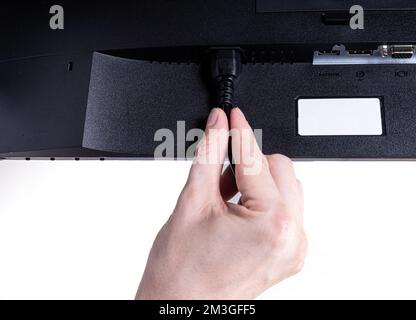 IT-Ingenieur man Hand führt Kabel in den Monitor ein. Mann Hand zum Anschließen des DVI-Kabels für Monitor an Computer-PC. VGA-DVI-DisplayPort und Netzkabel. cl Stockfoto