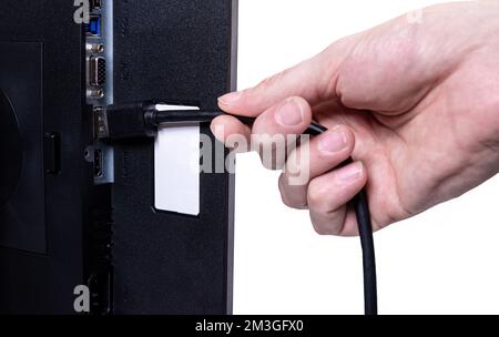 IT-Ingenieur man Hand führt Kabel in den Monitor ein. Mann Hand zum Anschließen des DVI-Kabels für Monitor an Computer-PC. VGA-DVI-DisplayPort und Netzkabel. cl Stockfoto