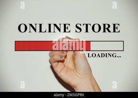 Hand einer Geschäftsfrau mit glitzernden Nägeln, die die Ladeleiste mit dem Text „Online-Shop“ zeigt Stockfoto
