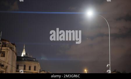 Nachthimmel mit Wolken. Action. Eine Stadt mit dunklem Himmel und schmutzigen Wolken im Hintergrund einer hellen Laterne, die die Architektur der Stadt beleuchtet. Stockfoto