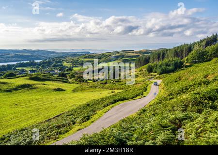 Ein Autofahrer auf der kurvenreichen B8073 Straße, der aus dem Dorf Dervaig auf der Isle of Mull, Schottland, Großbritannien, klettert Stockfoto