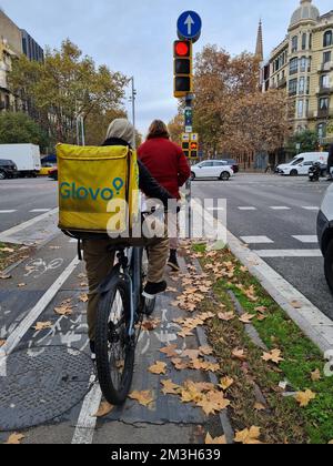 Glovo Liefermann wartet an einer roten Ampel mit seinem Fahrrad. Barcelona, Katalonien, Spanien. Stockfoto