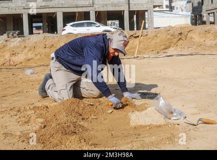 Gaza, Palästina. 15.. Dezember 2022. Ein palästinensischer Arbeiter arbeitet auf einem neu entdeckten Friedhof aus der Römerzeit im Gazastreifen. Die Hamas-Behörden in Gaza gaben die Entdeckung von über 60 Gräbern in der alten Grabstätte bekannt. Seit der Entdeckung des Geländes im Januar letzten Jahres während der Vorbereitungen für ein von Ägypten finanziertes Wohnungsbauprojekt wurden die Baustellen von Arbeitskräften ausgehoben. (Foto: Ahmed Zakot/SOPA Images/Sipa USA) Guthaben: SIPA USA/Alamy Live News Stockfoto