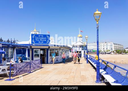 Eastbourne East Sussex blickt zurück entlang des Piers zu Menschen, die an Cafetstischen am Eastbourne Pier Eastbourne East Sussex England GB Europe saßen Stockfoto