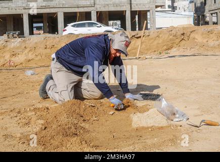 Gaza, Palästina. 15.. Dezember 2022. Ein palästinensischer Arbeiter arbeitet auf einem neu entdeckten Friedhof aus der Römerzeit im Gazastreifen. Die Hamas-Behörden in Gaza gaben die Entdeckung von über 60 Gräbern in der alten Grabstätte bekannt. Seit der Entdeckung des Geländes im Januar letzten Jahres während der Vorbereitungen für ein von Ägypten finanziertes Wohnungsbauprojekt wurden die Baustellen von Arbeitskräften ausgehoben. (Kreditbild: © Ahmed Zakot/SOPA Bilder über ZUMA Press Wire) Stockfoto