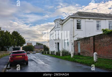 Mit dem quadratischen Turm der historischen St. Andrew's Church und der Aldborough Dorfhalle im Hintergrund, ein Blick durch das Dorf Aldborough Stockfoto