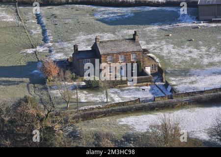 Eiskalter Morgen während einer Temperaturumkehr, in der Nähe von Bollington, Cheshire, mit Blick auf das Bauernhaus in Rainow Village von White Nancy Stockfoto