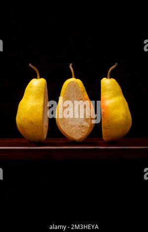 Drei Scheiben reifer Birnen auf einem Holzregal Stockfoto