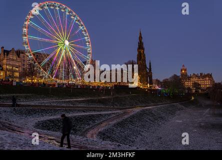 Edinburgh, Schottland, Vereinigtes Königreich, 15.. Dezember 2022. Weihnachten: Der Weihnachtsmarkt und Big Wheel werden in der Dämmerung mit Schnee auf dem Boden in den Princes Street Gardens beleuchtet. Kredit: Sally Anderson/Alamy Live News Stockfoto