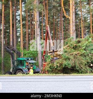 Traktor in der Nähe von Straßen entfernt gesägte Bäume. Schwere Geräte Stockfoto