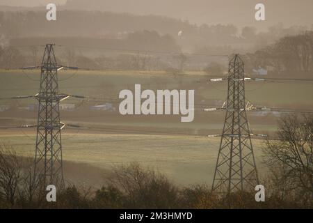 Elektrische Strommasten, angezündet von der Einstellung Sun, Dearham, Cumbria, England, Großbritannien Stockfoto