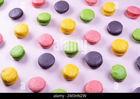 Hintergrund von süßen Makronen-Keksen in verschiedenen Farben auf pinkfarbenem Hintergrund. Stockfoto
