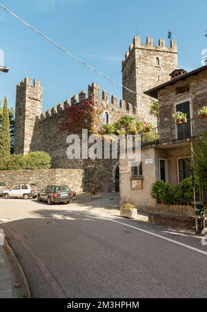 Rezzonico, San Siro, Lombardei, Italien - 18. Oktober 2022: Straße im Dorf San Siro mit mittelalterlicher Burg Rezzonico am Ufer des Sees Stockfoto