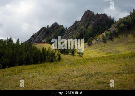 Winzige Häuser, umgeben von Bäumen auf dem Bergrücken. Kleine Hütten auf dem Hügelkamm an einem sonnigen Tag. Stockfoto