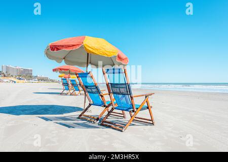 Galveston, TX, USA - 27. Oktober 2019: Farbenfrohe Strandliegen und Sonnenschirme auf Galveston Island Texas. Stockfoto