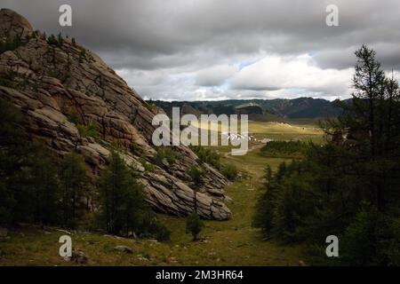 Winzige Häuser, umgeben von Bäumen auf dem Bergrücken. An einem sonnigen Tag auf dem Hügelkamm kleine Ger-Hütten. Stockfoto