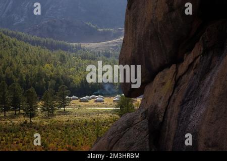 Winzige Häuser, umgeben von Bäumen auf dem Bergrücken. An einem sonnigen Tag auf dem Hügelkamm kleine Ger-Hütten. Stockfoto