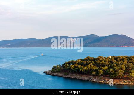 Ein traditionelles hölzernes Fischerboot, das auf dem farbenfrohen Wasser schwimmt, Ermioni, Griechenland. Stockfoto
