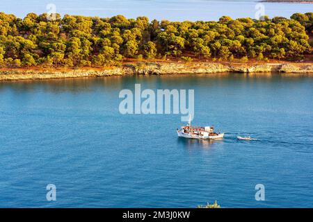 Ein traditionelles hölzernes Fischerboot, das auf dem farbenfrohen Wasser schwimmt, Ermioni, Griechenland. Stockfoto
