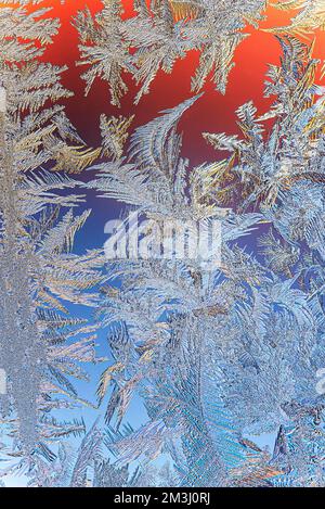 Wintereis- und Frostmuster auf dem Fensterglas. Hintergrund für Weihnachten und Neujahr. Makro-Nahaufnahme Stockfoto