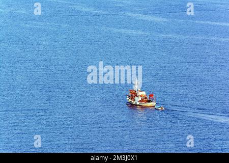 Ein traditionelles hölzernes Fischerboot, das auf dem farbenfrohen Wasser schwimmt, Ermioni, Griechenland. Stockfoto
