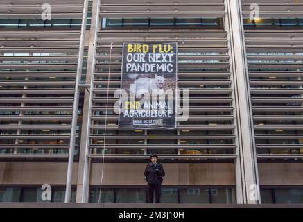 London, Großbritannien. 15.. Dezember 2022. Ein Polizist steht unter dem Banner Wache. Tierschutzprotestierende der Gruppe Animal Justice Project hängten ein riesiges Banner vor dem Innenministerium, in dem auch das Department for Environment, Food and Rural Affairs (DEFRA) untergebracht ist, und forderten ein Ende der Tierzucht, um die nächste Vogelgrippe-Pandemie zu verhindern. (Kreditbild: © Vuk Valcic/ZUMA Press Wire) Kredit: ZUMA Press, Inc./Alamy Live News Stockfoto