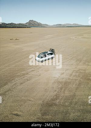 Luftaufnahme eines selbst umgebauten Wohnwagens, das auf einem trockenen Seegrund in der Wüste des südlichen nevada, USA, mit Solarzellen fährt Stockfoto