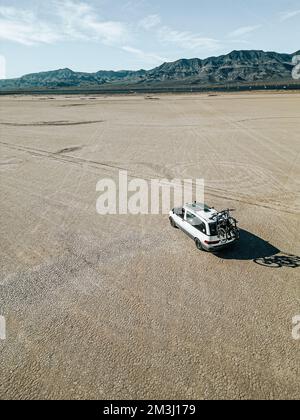 Luftaufnahme eines selbst umgebauten Wohnwagens, das auf einem trockenen Seegrund in der Wüste des südlichen nevada, USA, mit Solarzellen fährt Stockfoto