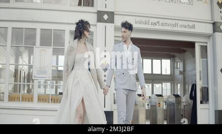 Türkei, Istanbul - 27. Juli 2022: Junges und wunderschönes Hochzeitspaar, das spaziert und Händchen hält. Aktion. Braut und Bräutigam draußen in der Stadtstraße Stockfoto