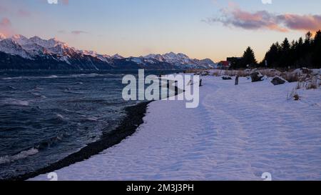 Schneestrand mit Bergkette und Sonnenuntergang in Seward, Alaska Stockfoto