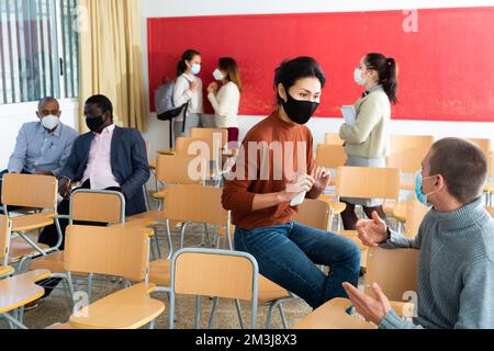 Schüler tragen im Klassenzimmer eine Schutzmaske Stockfoto