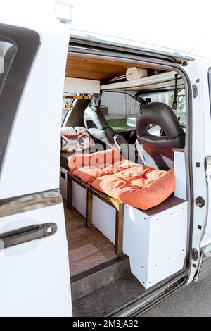 Wunderschönes helles natürliches Licht, das einen alten selbst umgebauten Kleinbus für das Leben im Kleinbus betritt und beleuchtet. Das Vanlife Freizeitfahrzeug verfügt über oder Stockfoto