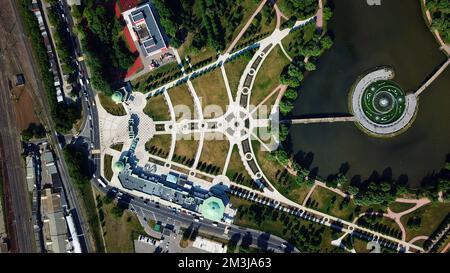 Draufsicht auf einen Stadtpark mit rundem Teich. Kreativ. Sommerpark mit kleinen Wegen und grünen Bäumen Stockfoto