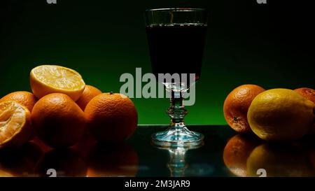 Rumgetränk wird in langes Glas gegossen, isoliert auf farbenfrohem beleuchtetem Wandhintergrund. Clip. Alkoholgetränk auf dem reflektierenden Tisch oder an der Theke Stockfoto