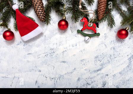 Weihnachtszusammensetzung von Tannenzapfen, Pinienzapfen und Weihnachtsschmuck auf weißgrauem Hintergrund mit Textkopie. Weihnachten und neu Stockfoto