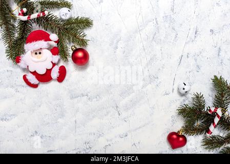 Weihnachtszusammensetzung von Tannenzapfen, Pinienzapfen und Weihnachtsschmuck auf weißgrauem Hintergrund mit Textkopie. Weihnachten und New Ye Stockfoto