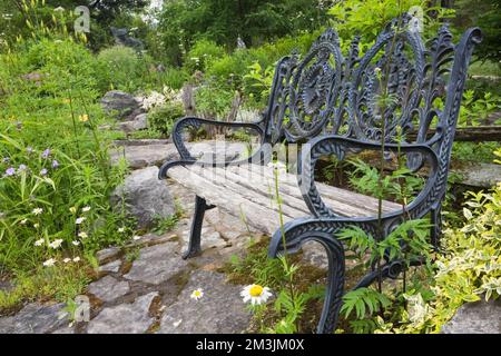 Antiker viktorianischer Gusseisen- und Holzgarten im Gartengarten im Sommer. Stockfoto