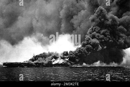 Amerikanischer Flugzeugträger, USS 'Bunker Hill', brennt, nachdem er von zwei japanischen 'Kamikaze'-Selbstmordattentätern, Pazifik, 1945, getroffen wurde. Stockfoto