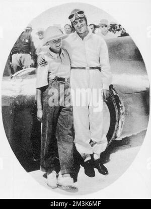 Sir Malcolm Campbell (1885 - 1948), sein Sohn Donald Campbell (1921 - 1967), steht neben „Bluebird“ nach einem von Malcolms Geschwindigkeitsrekordversuchen auf Utah Salt Flats. Stockfoto