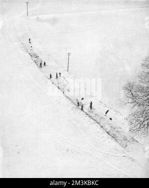 Eine Luftaufnahme zeigt Mannschaften, die sich durch Drifts in das Dorf Bredhurst durchschneiden, das zwar nur sechs Meilen von Chatham in Kent entfernt war, aber für kurze Zeit komplett von der Außenwelt abgeschnitten war. An einigen Stellen waren die Drifts mehrere Fuß tief und kein Straßenabschnitt hatte weniger als 2 Fuß Schnee. Diese Szene ist typisch für den Winter 1947, eine der härtesten in der britischen Geschichte. Datum: 1947 Stockfoto